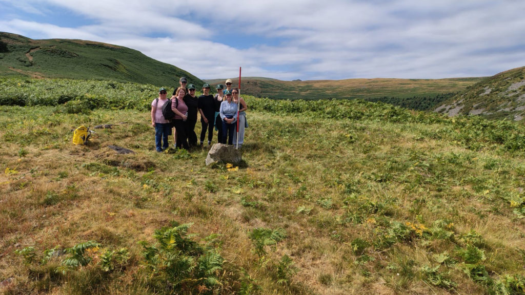 Volunteers by a marker stone in the park